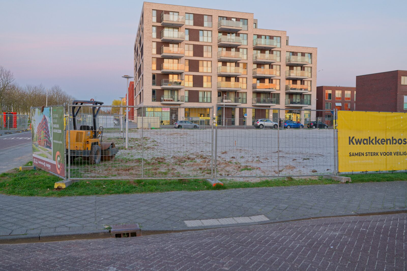 Site fenced off, banners and small roller, dusk